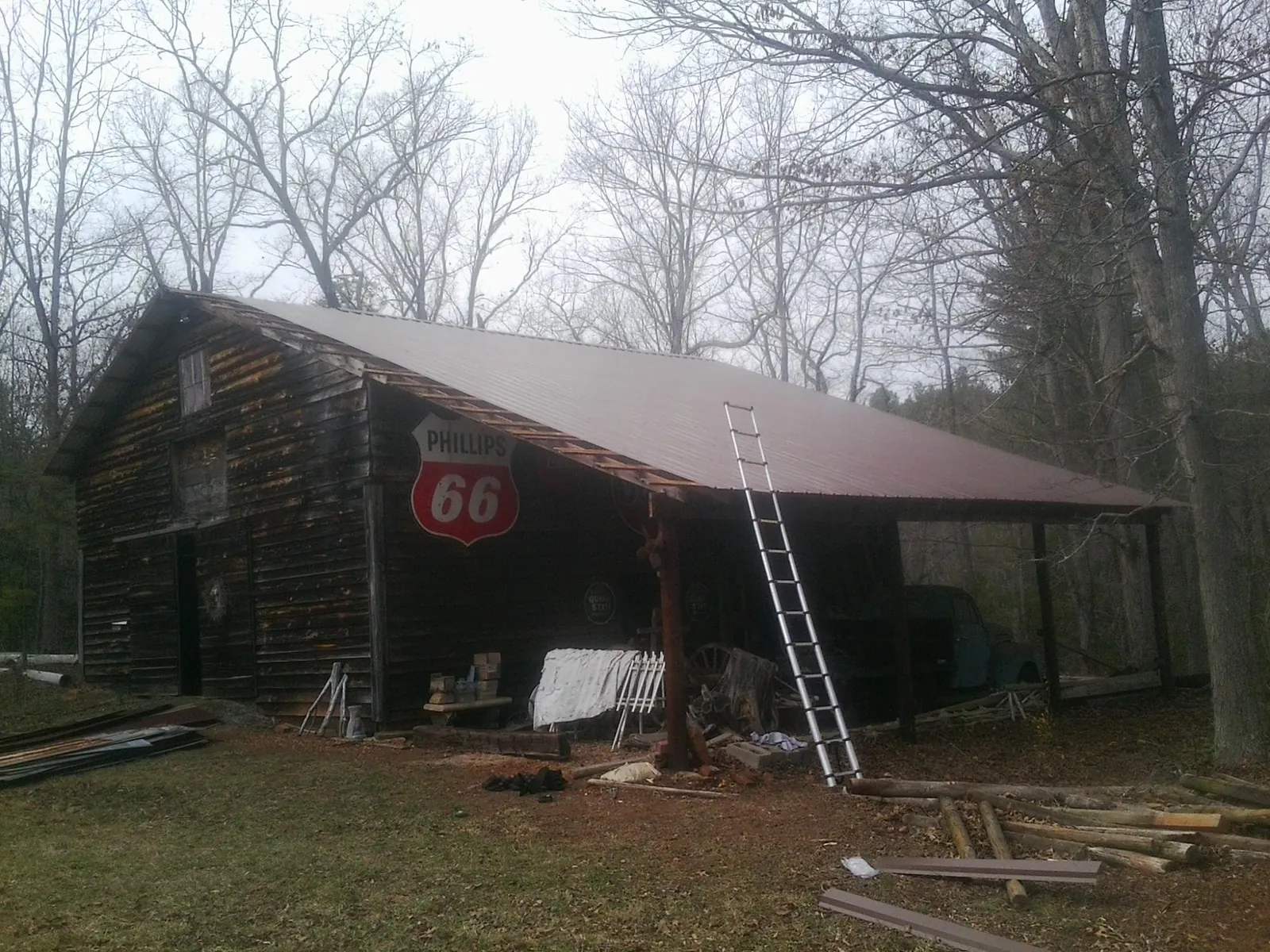 New metal roof on an open sided timber barn with a vintage sign in Harrah