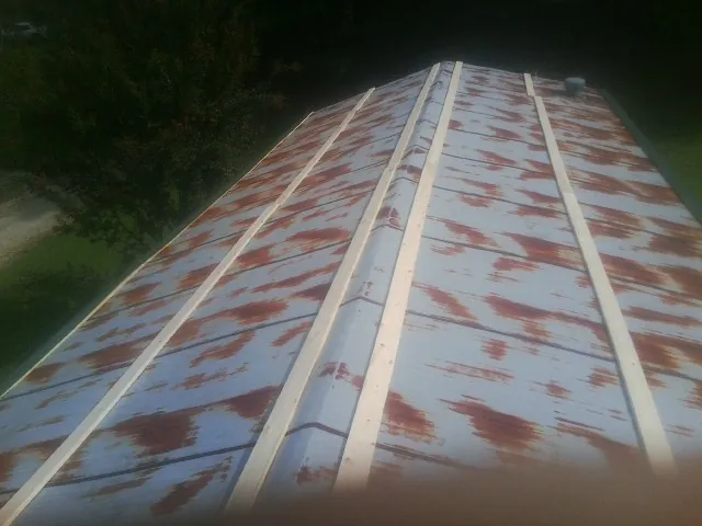 Rusted metal roof panels with new wood purlins before replacement — Storm Damage Roof Repair in Harrah by Roofing Brothers